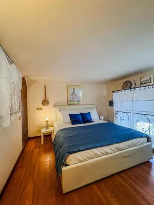 a bedroom with a large bed with blue pillows at Trastevere Tranquility Rome in Rome