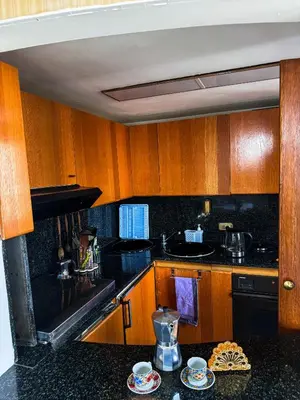 a kitchen with wooden cabinets and a black counter top at Trastevere Tranquility Rome in Rome