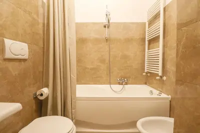 a bathroom with a tub and a toilet and a sink at Free Parking Chic Home - Balcony, AC, Wi-Fi in Rome