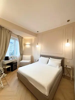 a bedroom with a large white bed and a chair at GLhouse Roma Mazzini in Rome