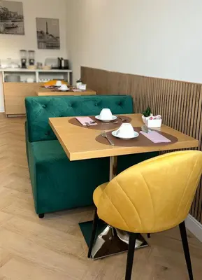a green couch with a table and a yellow chair at GLhouse Roma Mazzini in Rome