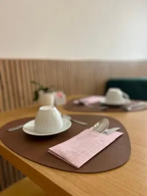 a wooden table with two plates and a napkin at GLhouse Roma Mazzini in Rome