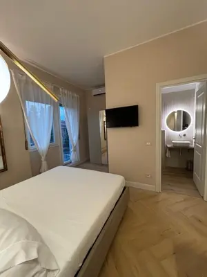 a bedroom with a large white bed and a mirror at GLhouse Roma Mazzini in Rome