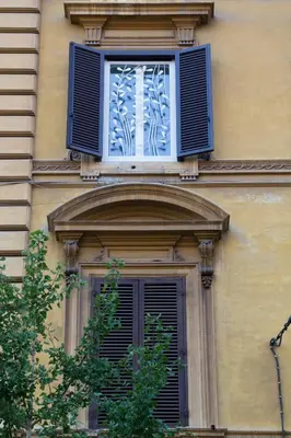 a window with a blue shutter on a building at La Casa Di Iulia in Rome