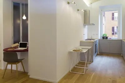 a kitchen with a table and a laptop on a counter at La Casa Di Iulia in Rome