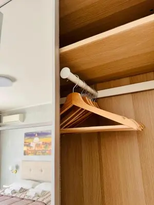 a closet with a wooden door with a hanger at Step to the Vatican in Rome