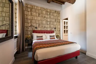 a bedroom with a large bed with a red headboard at Maison Evelina in Rome