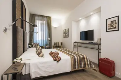a hotel room with a bed and a television at Maison Evelina in Rome