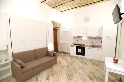 a living room with a couch and a kitchen at Il Mattoncino - Colosseo in Rome