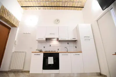 a kitchen with white cabinets and a stove at Il Mattoncino - Colosseo in Rome