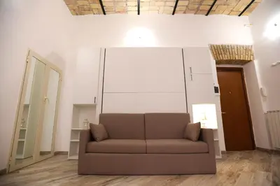 a living room with a couch and a large white wall at Il Mattoncino - Colosseo in Rome