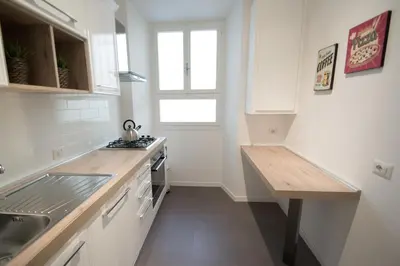 a white kitchen with a sink and a counter at Vantaggio Apartment in Rome