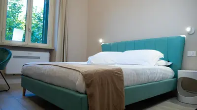 a bed with a blue couch in a room at Suites 215 Colosseum - Guesthouse in Rome
