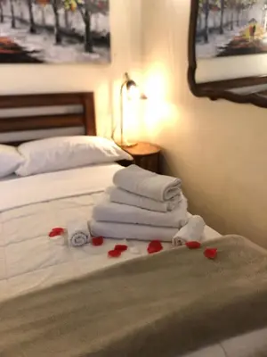 a bed with towels and red roses on it at Trastevere Holiday Home in Rome