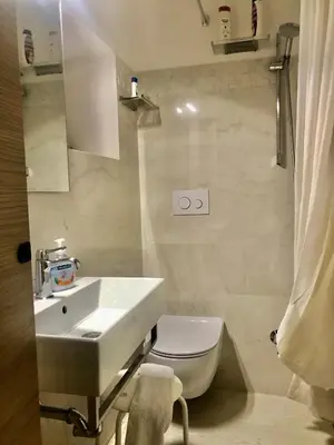 a white bathroom with a sink and a toilet at Trastevere Holiday Home in Rome