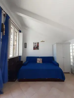 a bedroom with a blue bed in a white room at Loft Capodistria, Rome, in Rome