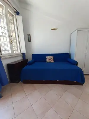 a bedroom with a blue bed in a room at Loft Capodistria, Rome, in Rome