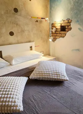 a bedroom with a bed with a brick wall at Conte Apartment - Roma San Pietro in Rome
