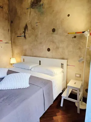 a bedroom with two beds and a wall with rocks at Conte Apartment - Roma San Pietro in Rome