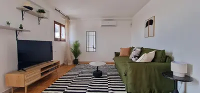 a living room with a green couch and a flat screen tv at Nox Romana Apartment - Polyclinic Gemelli - Penthouse with Large Panoramic View Terrace in Rome