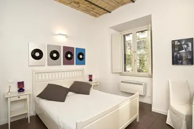 a white bedroom with a white bed and a window at Germanico Maxi in Rome