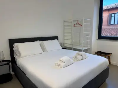 a bedroom with a large white bed with towels on it at Rome design and fitness stay - Pantheon and Trevi in Rome