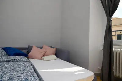 a bed with pink and blue pillows on it at A due passi dal Colosseo - Vista città - Luxury in Rome