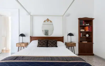 a bedroom with a white bed with two night stands at Historic 3BR Colosseum Apartment 160sqm for 9 in Rome
