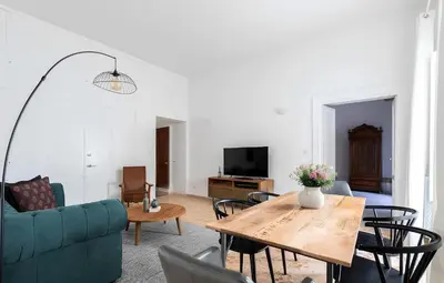 a living room with a blue couch and a table at Historic 3BR Colosseum Apartment 160sqm for 9 in Rome