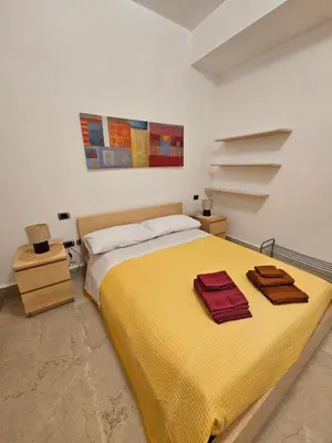 a bedroom with a large bed with a yellow blanket at SWEET HOME Porta Maggiore in Rome