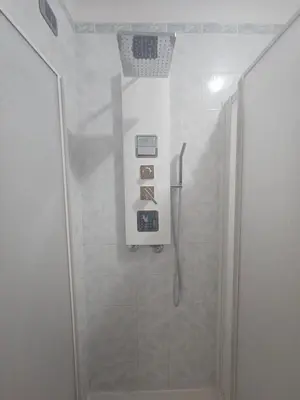 a shower stall in a bathroom with a basket on the wall at SWEET HOME Porta Maggiore in Rome