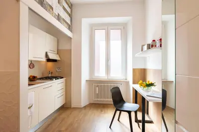 a small kitchen with a table and a chair at Clio Rome Suite 2 bedroom 2 bathroom apartment in Rome