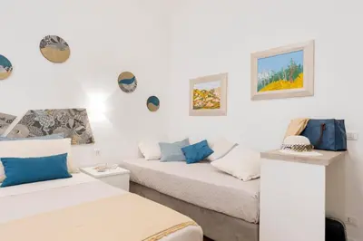 a room with two beds and a couch at Clio Rome Suite 2 bedroom 2 bathroom apartment in Rome