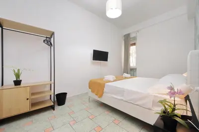 a white bedroom with a bed and a mirror at Domus Sinuessa in Rome