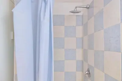 a shower with a white shower curtain in a bathroom at Domus Sinuessa in Rome