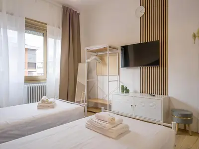 a bedroom with two beds and a flat screen tv at Relax e Style, Kairos, the house of quality time in Rome