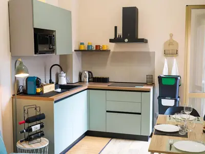 a kitchen with white cabinets and a table with a tableablish at Relax e Style, Kairos, the house of quality time in Rome