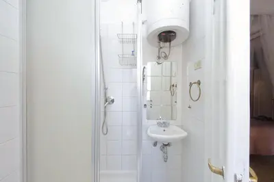 a white bathroom with a sink and a shower at Pascarella - Trastevere in Rome