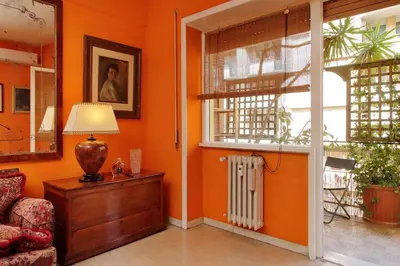 an orange room with a couch and a lamp and a window at Pascarella - Trastevere in Rome