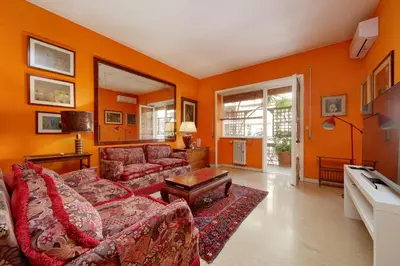 a living room with orange walls and a couch at Pascarella - Trastevere in Rome