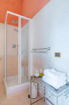 a bathroom with a shower and a table with towels at Residenza Episcopo Lipinsky 1902 in Rome