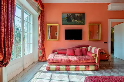 a living room with a red couch and a tv at Residenza Episcopo Lipinsky 1902 in Rome