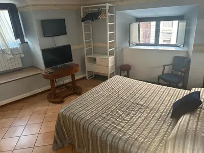 a bedroom with a bed and a television and a table at Apt Aurea Domus al Pantheon in Rome