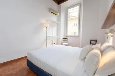 a white bedroom with a white bed and a window at Pantheon-Rondanini - Cozy Apartment in Rome