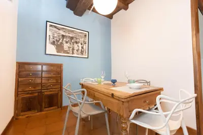 a dining room with a wooden table and white chairs at Pantheon-Rondanini - Cozy Apartment in Rome