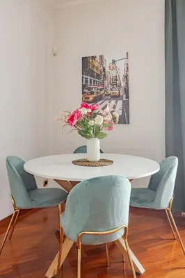a dining room table with chairs and a vase of flowers at Family House 10 Min Metro Conca d'Oro in Rome