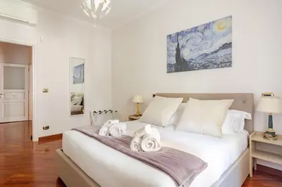 a bedroom with a large white bed with towels on it at Family House 10 Min Metro Conca d'Oro in Rome