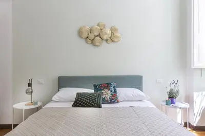 a white bedroom with a large bed with two tables at Maison Haysée Piazza del Popolo in Rome