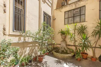 a fountain in front of a building with potted plants at Maison Haysée Piazza del Popolo in Rome