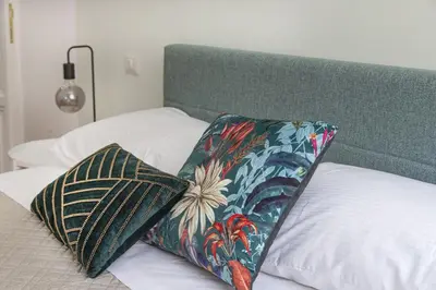 a bed with a green headboard with a pillow on it at Maison Haysée Piazza del Popolo in Rome